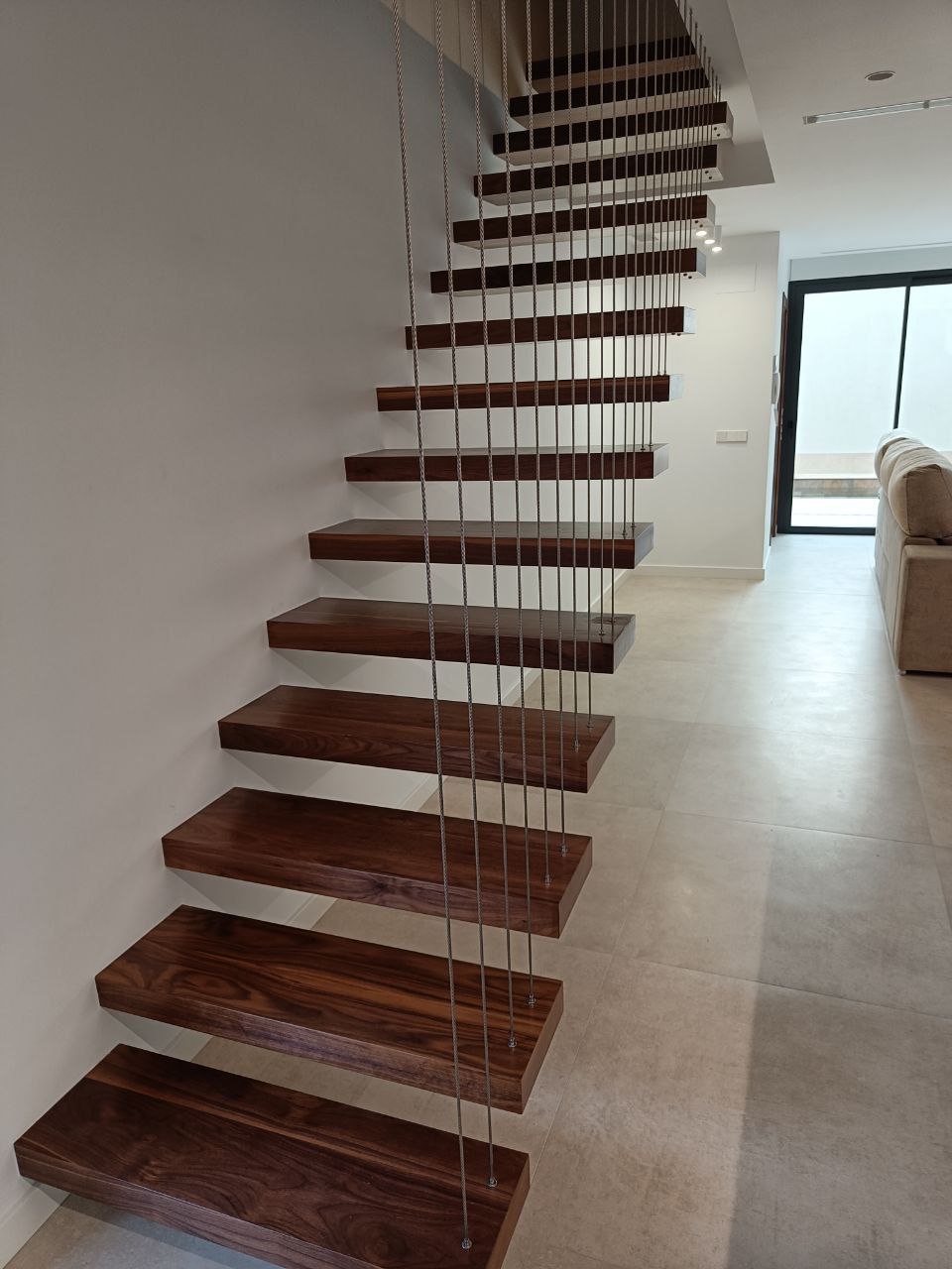 Escalera volada de madera de nogal con barandilla de cables